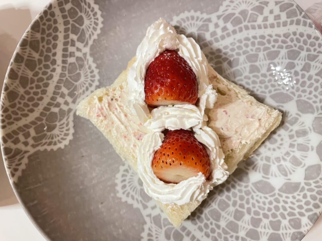 食パンにのせた苺をホイップで囲んでいる