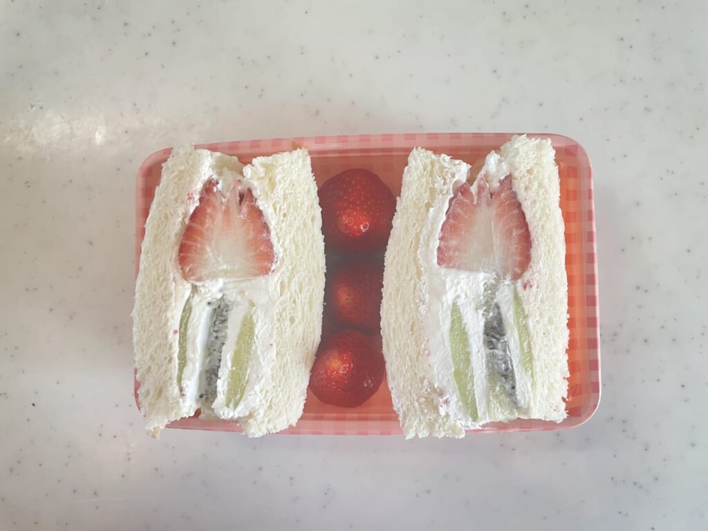 出来たサンドをパックに詰めている