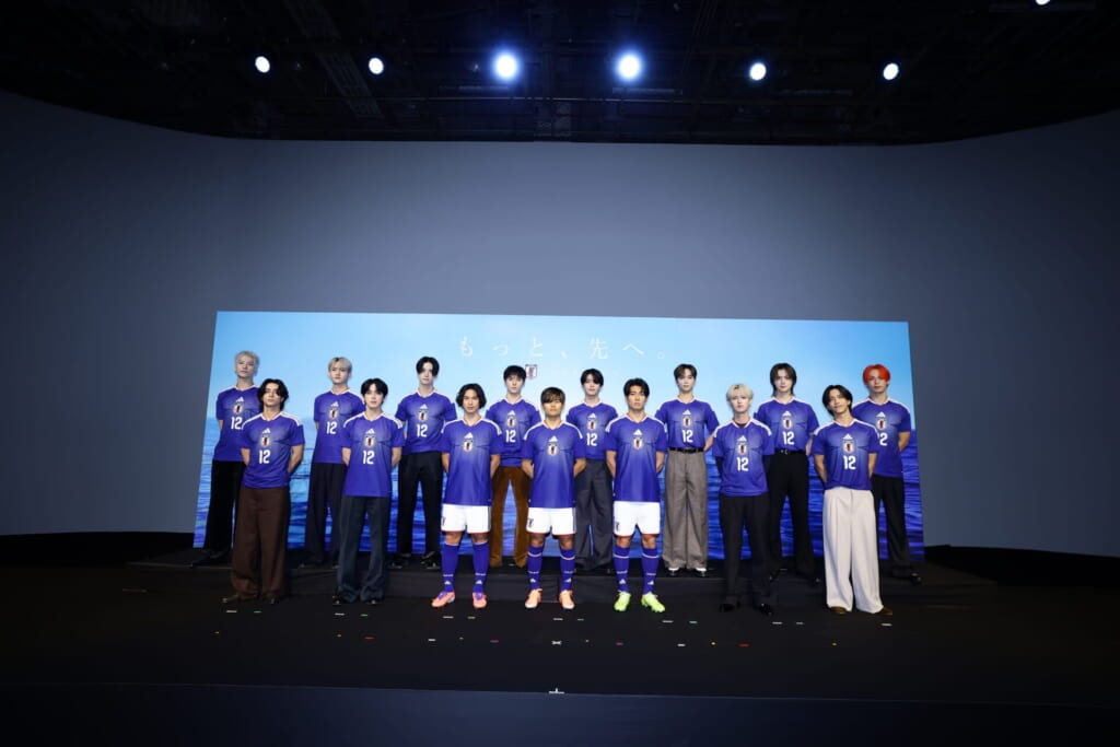 サッカー日本代表の南野拓実選手、久保建英選手、中村敬斗選手と壇上で撮影するJI BLUE