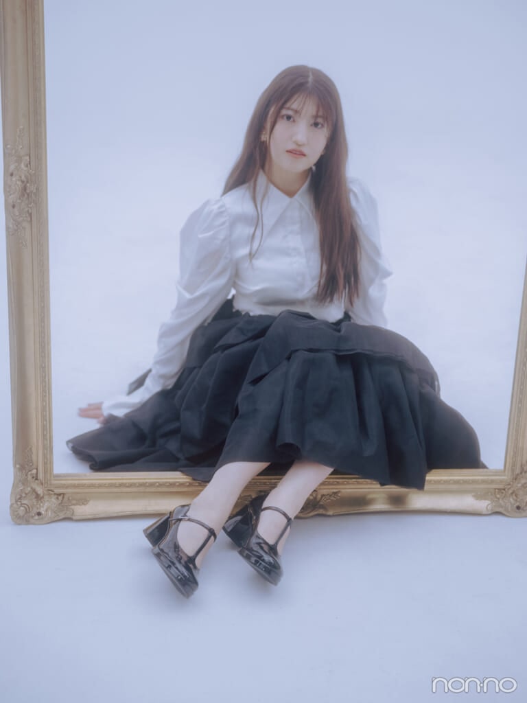 大きな額縁の中に座る、モノトーンのクラシカルなコーデを着こなしたモーニング娘。’25の羽賀朱音さん