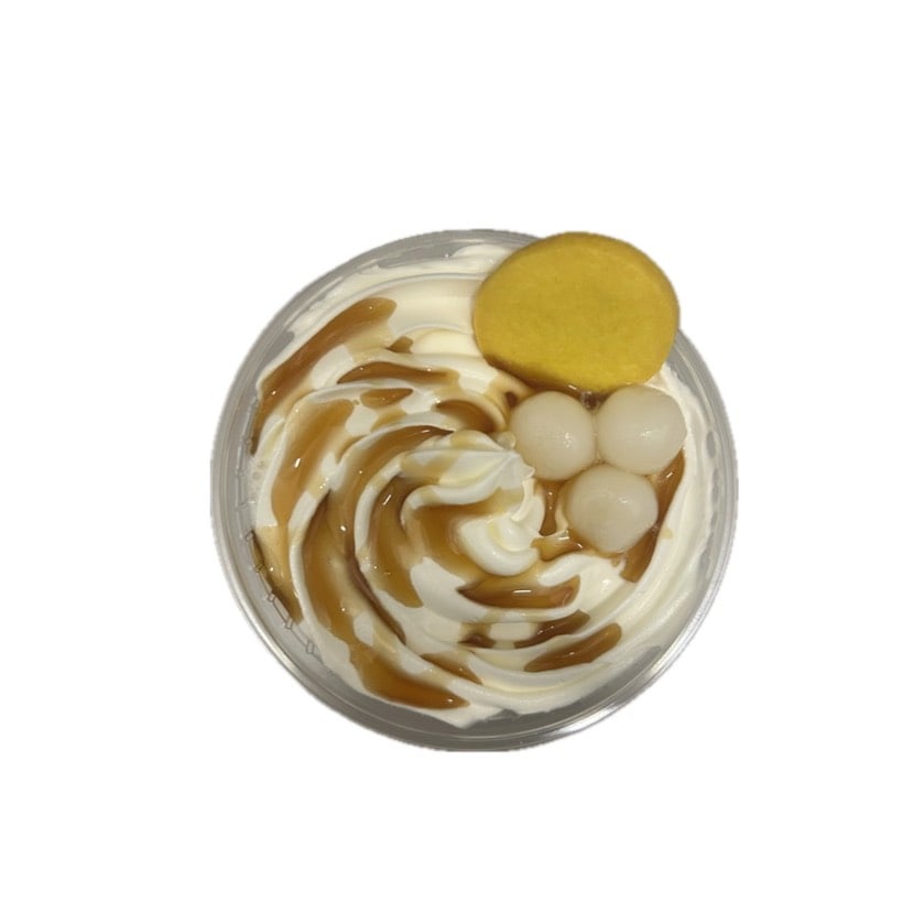 ドリンクを上から撮影した写真。ホイップと白玉三つ、黄色いクッキー、ソースが乗っている。