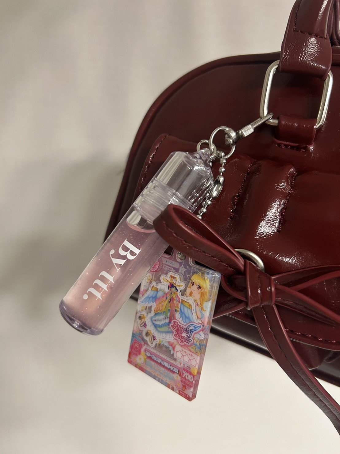 赤のカバンにキーホルダー型のグロスとアイカツチャームを付けた画像