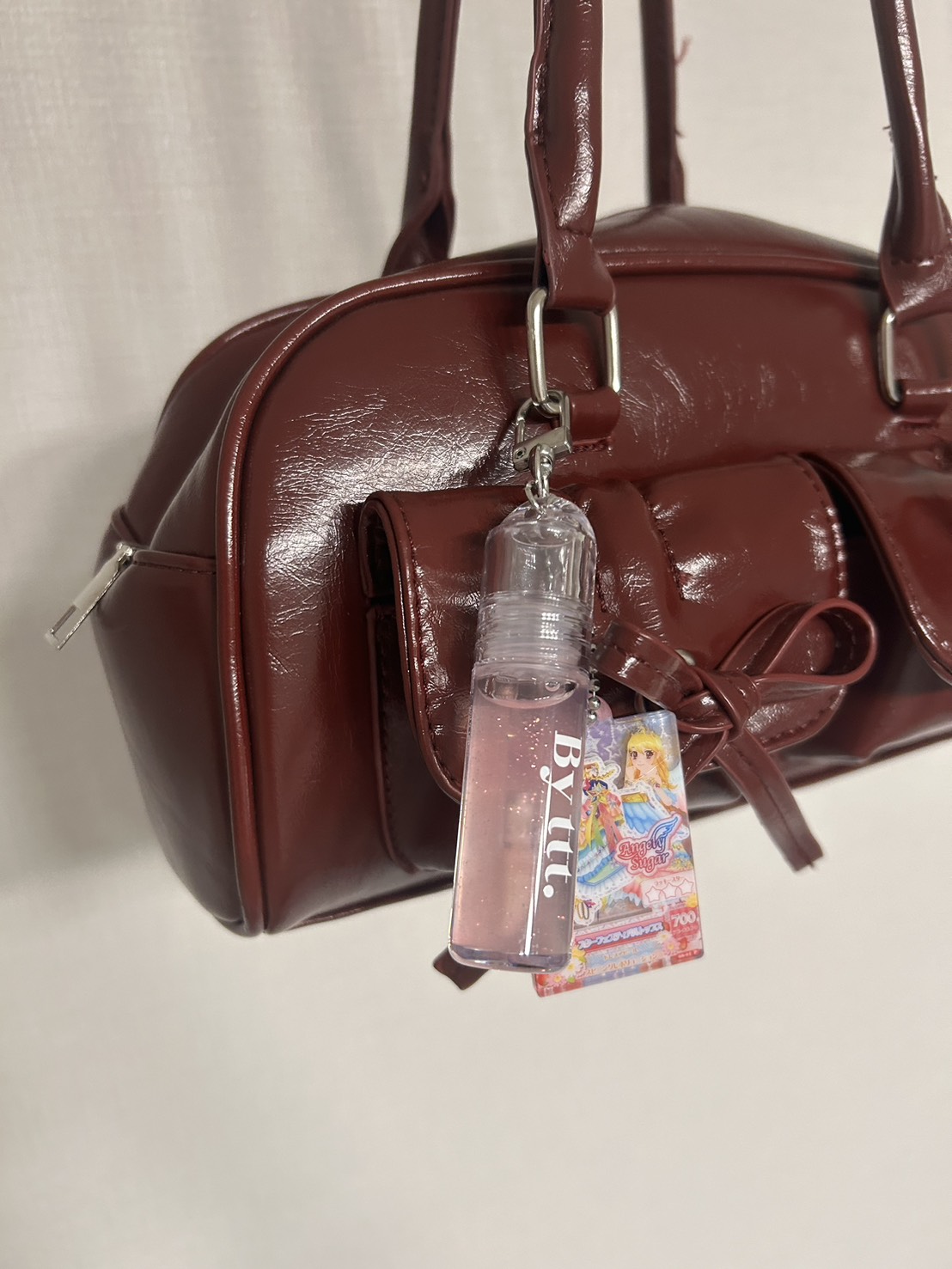 赤のカバンにキーホルダー型のグロスとアイカツチャームを付けた画像