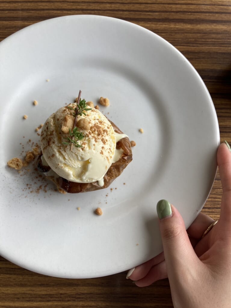焼きリンゴの上にバニラアイスが乗っている画像。