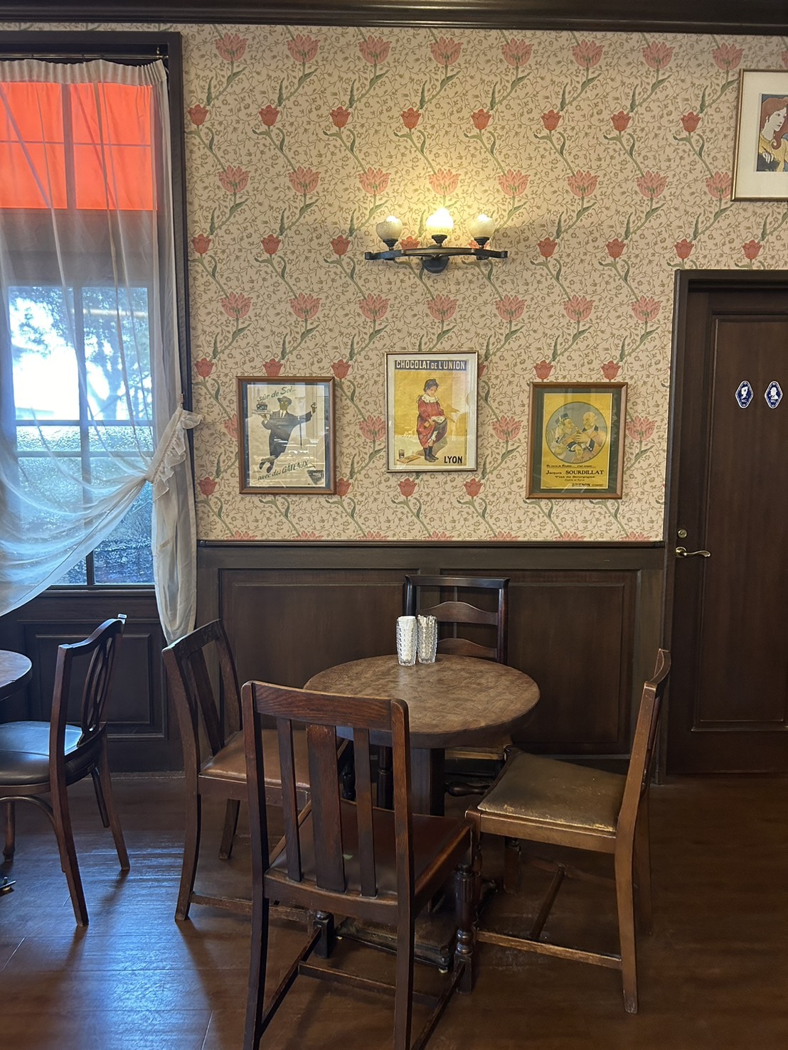 花柄の壁にイラストが飾られている