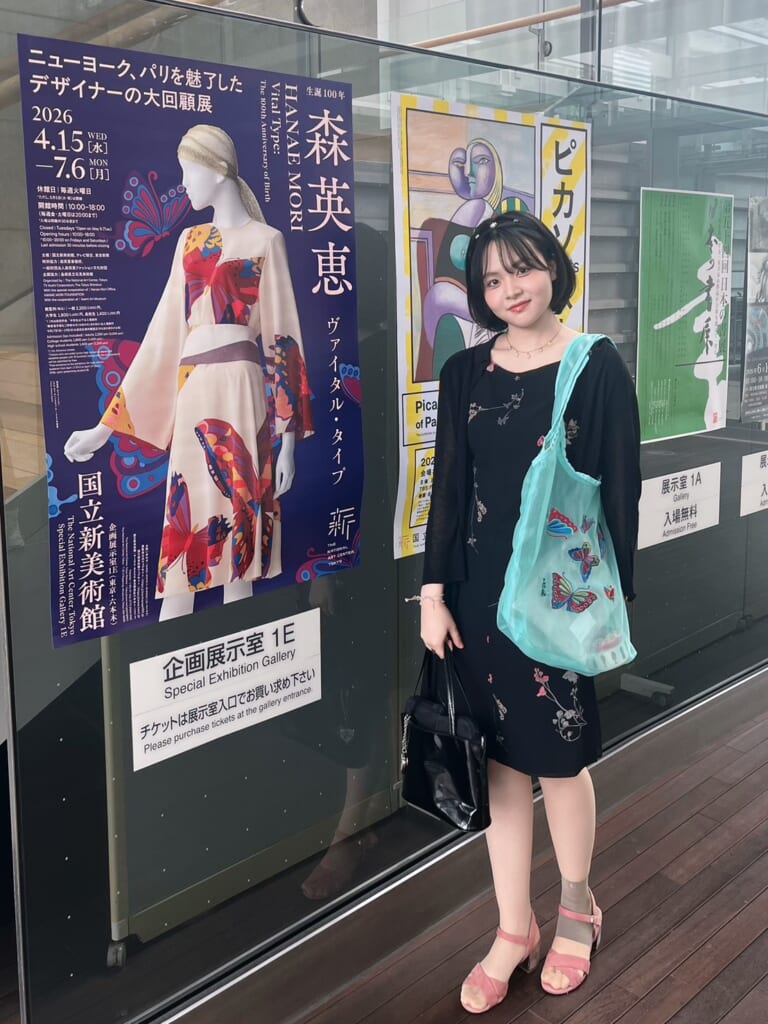人物　「森英恵　ヴァイタルタイプ」のポスターの前に立つ