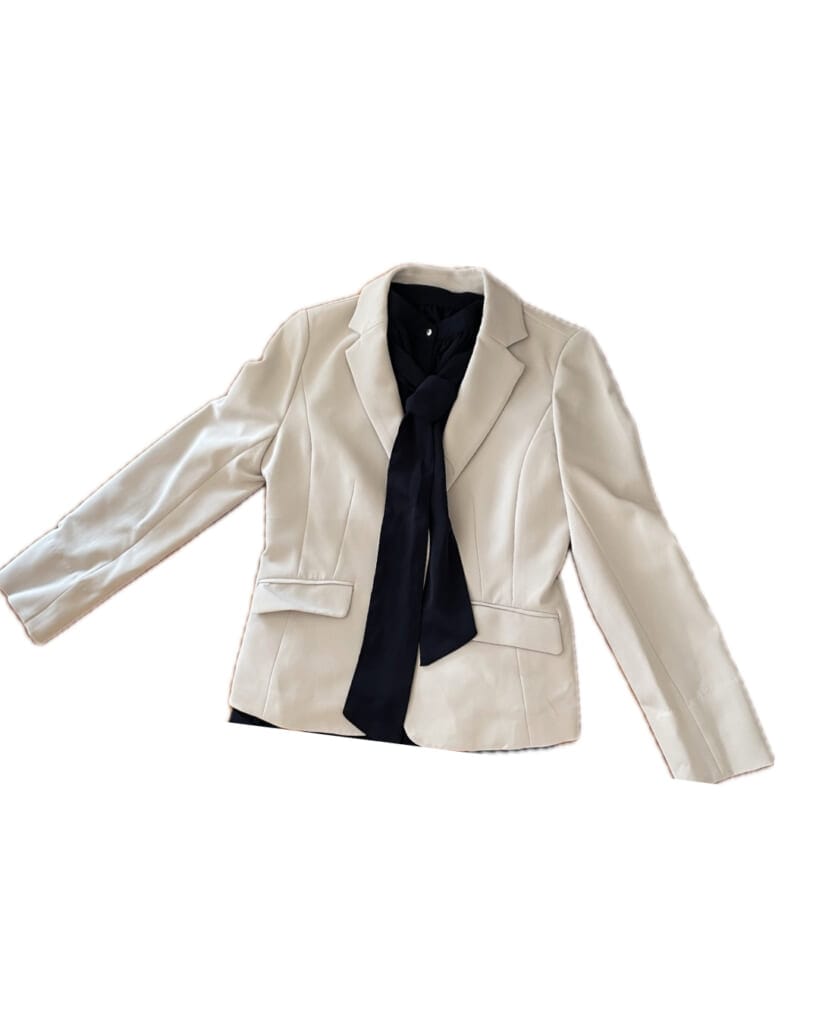 白のジャケット、紺のボウタイブラウス。