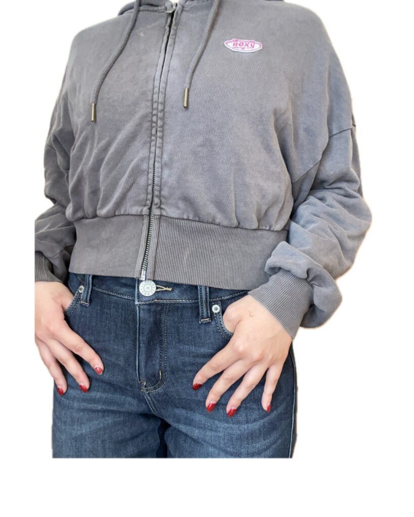 グレーのショート丈パーカー着用。