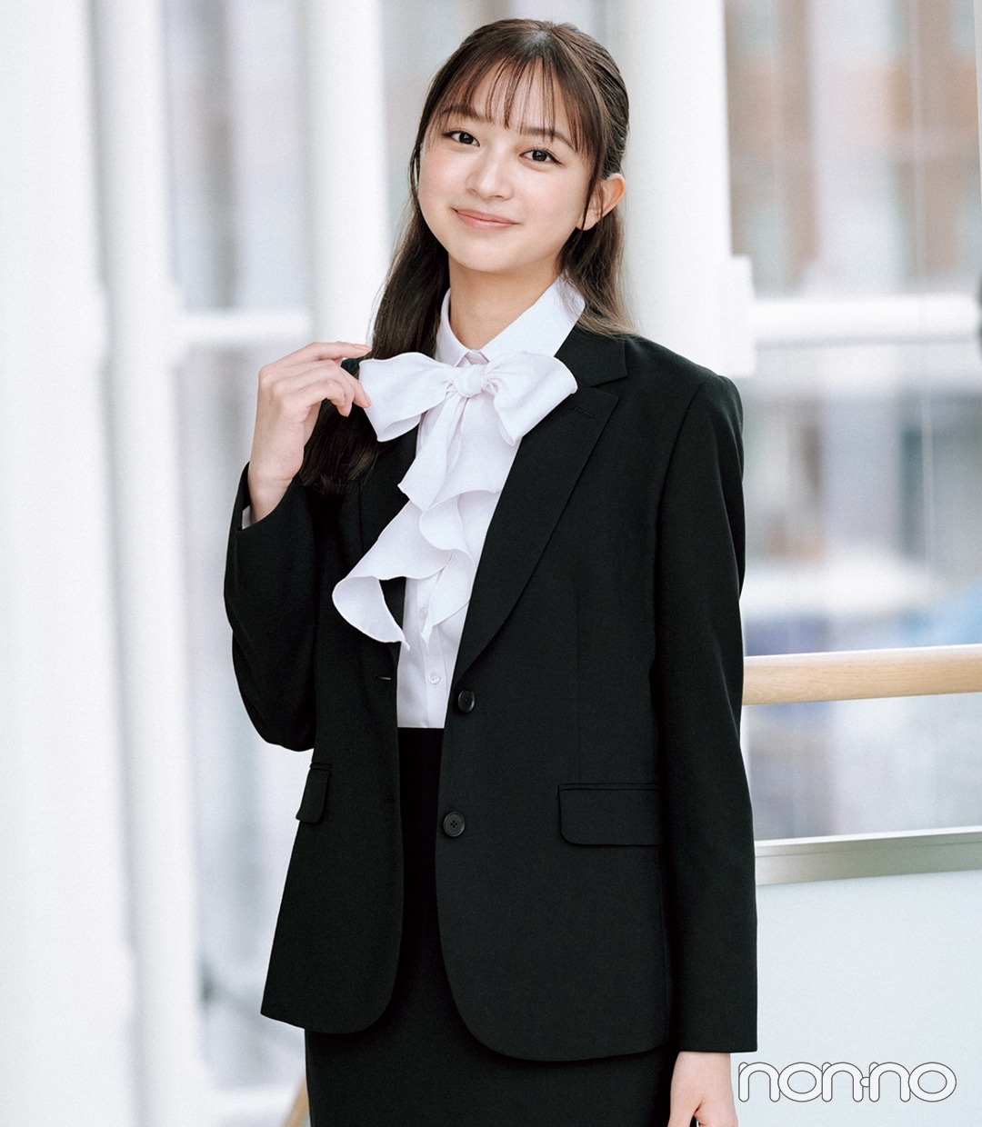 大学入学式の女性のスーツにおすすめのピンクのボウタイブラウスを
着た女性