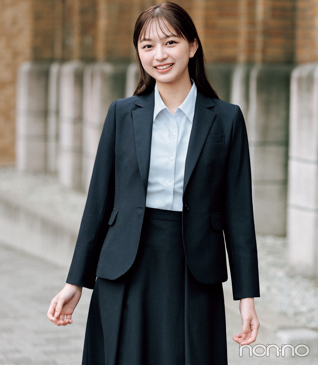 大学入学式の女性のスーツにおすすめのブルーのスキッパーブラウスを
着た女性