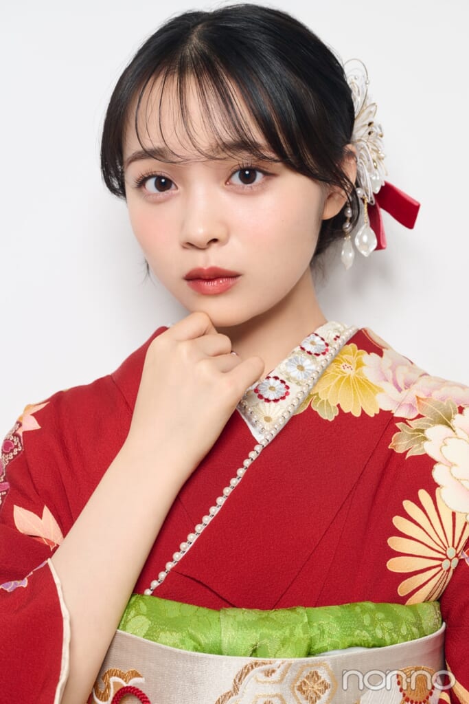 赤い着物を着て手に顔をあてる林芽亜里