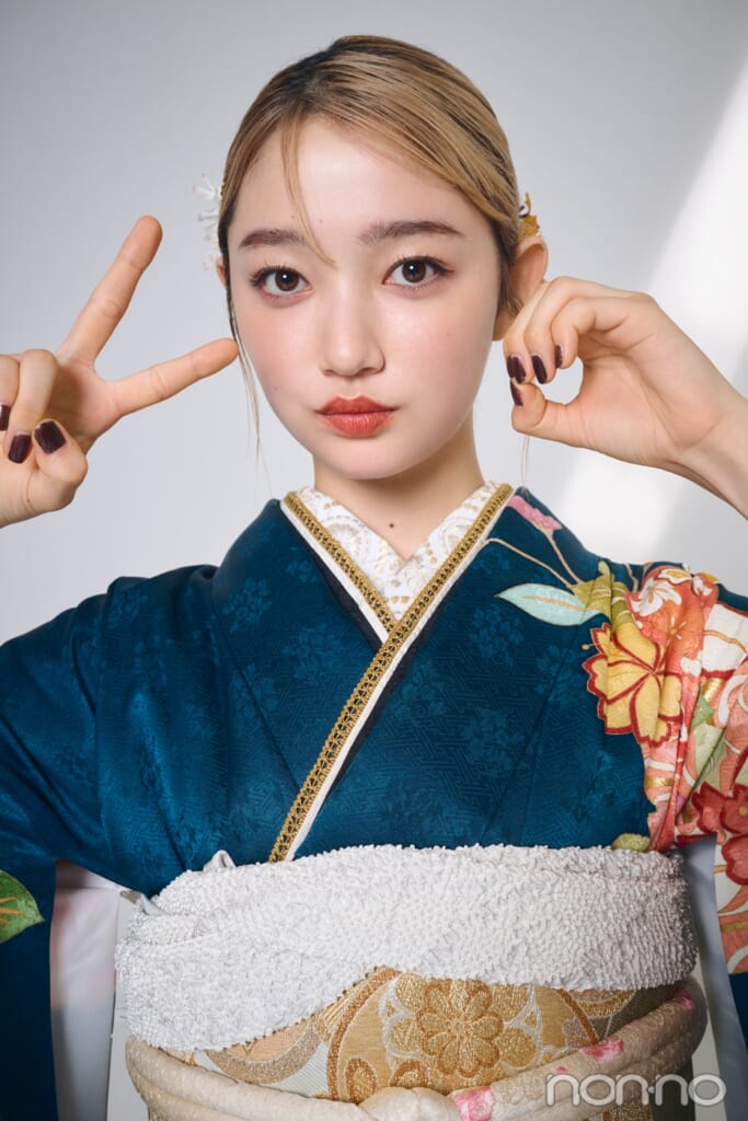 グリーンの振袖を着て顔の前で２と０をつくる小宮山莉渚