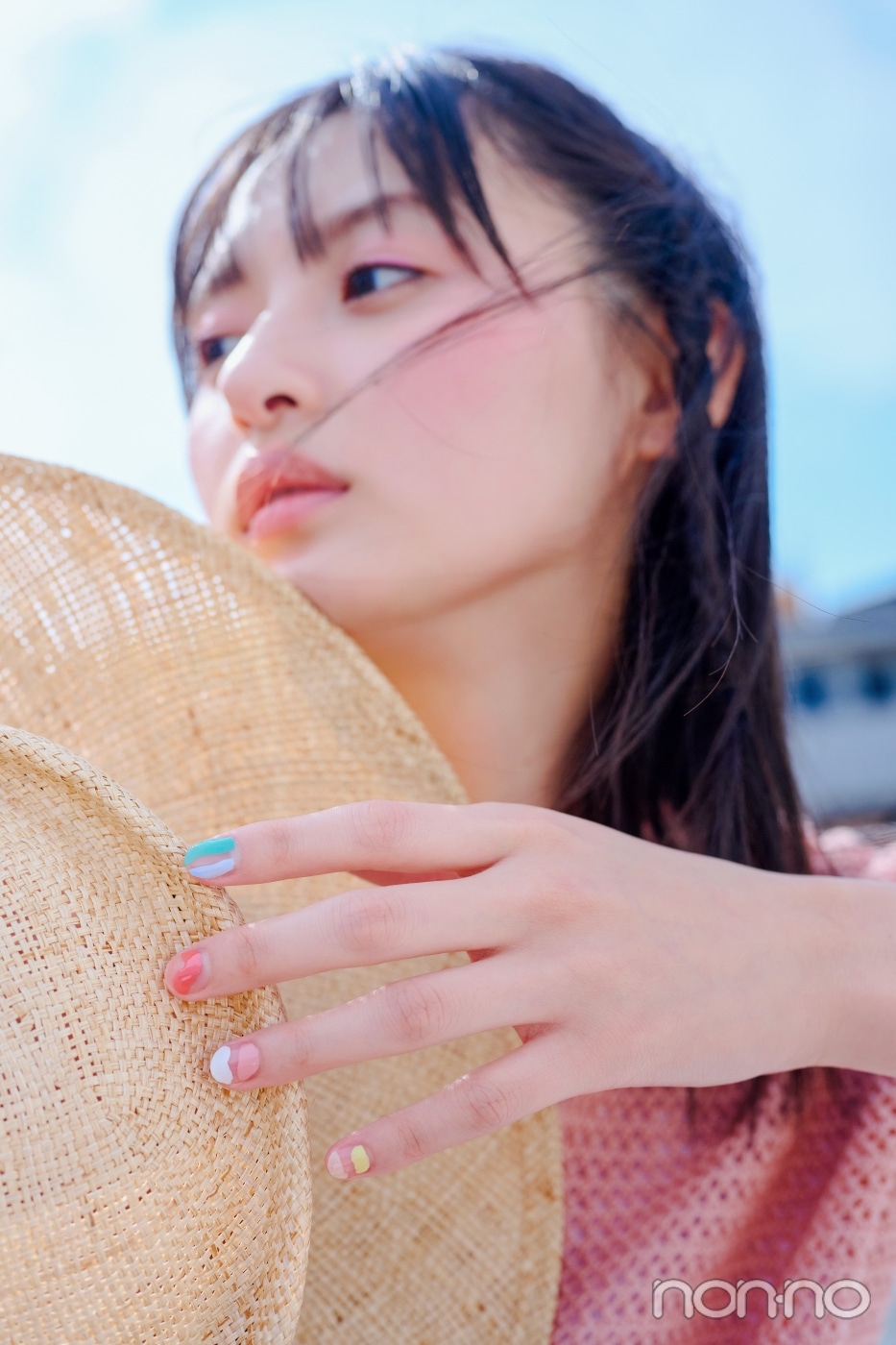 麦わら帽子を持って横を向く遠藤さくら