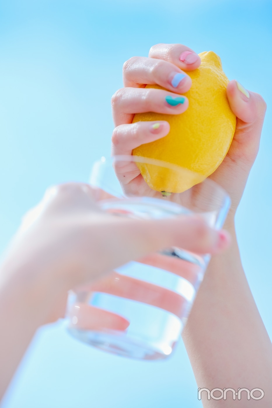 レモンと水の入ったグラスを持った手元