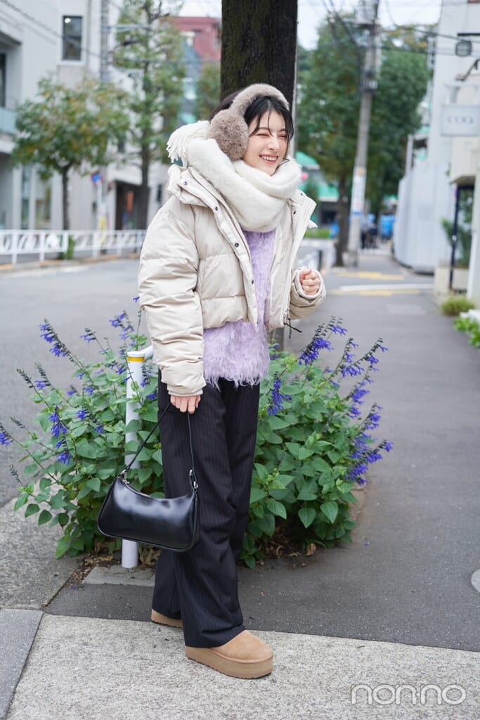 白いダウンにストライプパンツを履いた出口夏希の全身