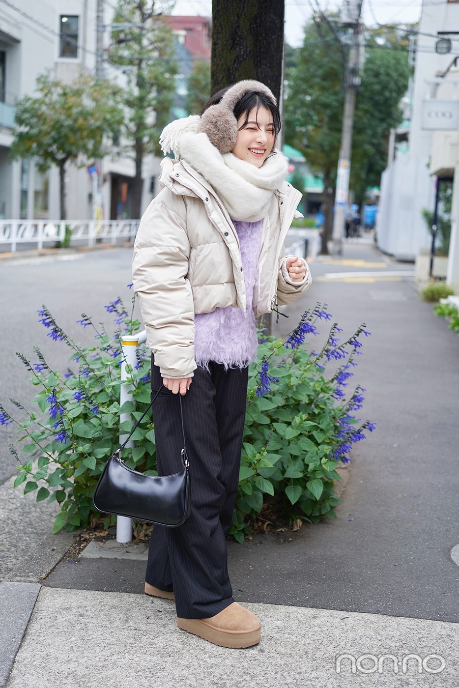 白いダウンにストライプパンツを履いた出口夏希の全身