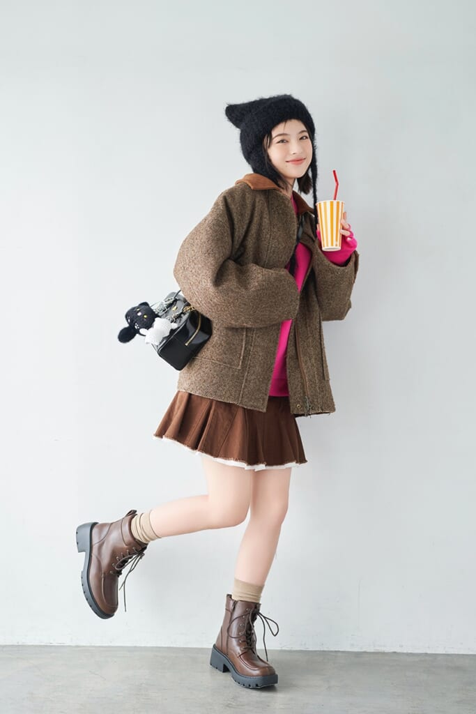 ピンクのニットに黒い帽子を被った出口夏希の全身