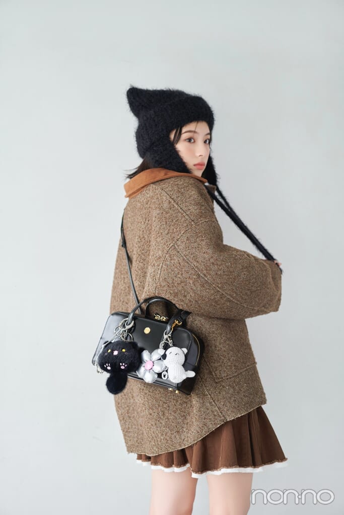 チャームをつけたバッグを斜めがけする出口夏希の後ろ姿