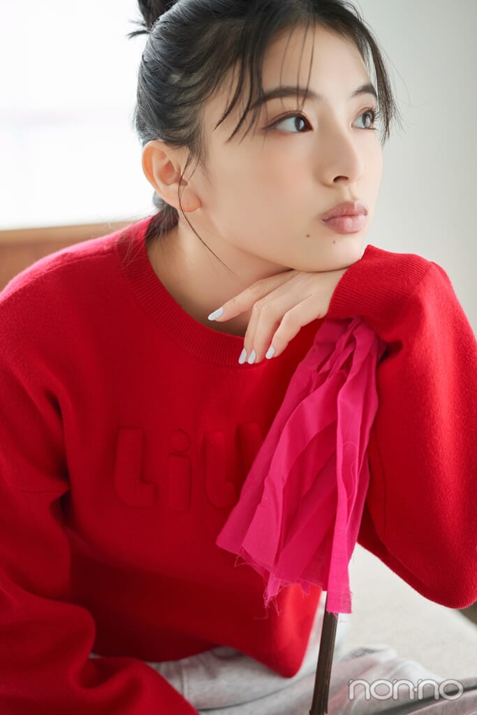 赤いニットで横を向く出口夏希のバストアップ