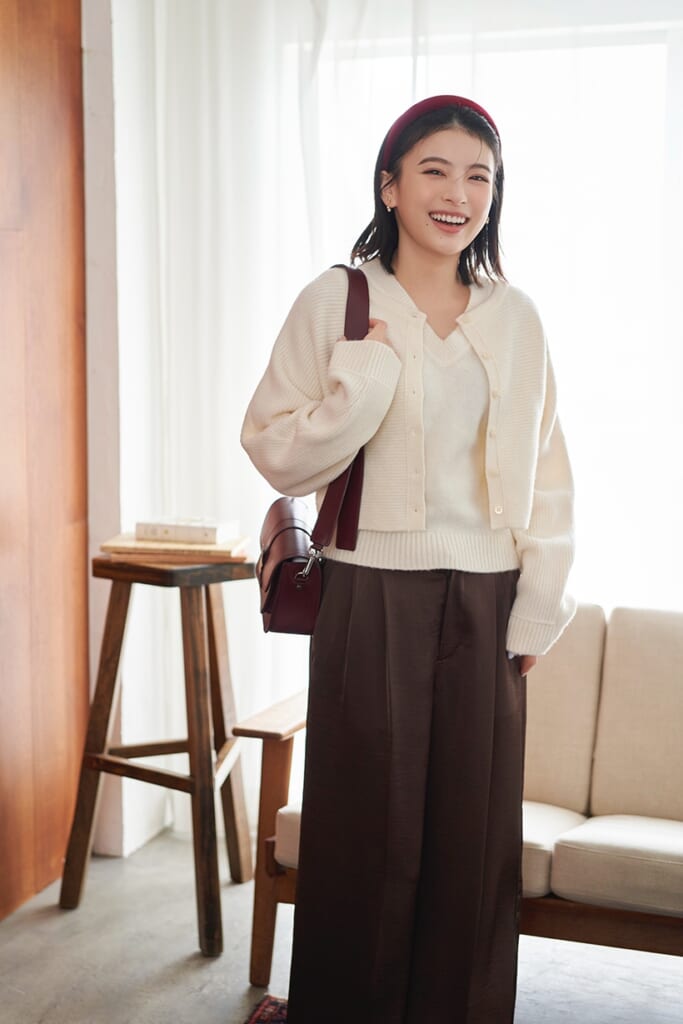 白ニットアンサンブルにブラウンパンツを履いた出口夏希の全身