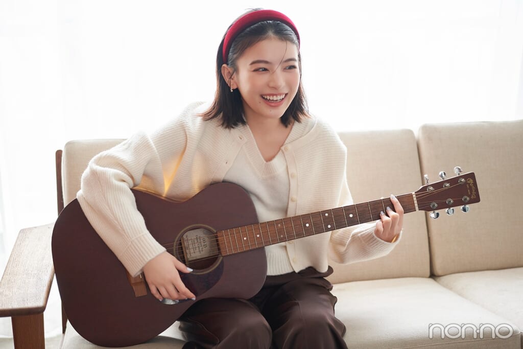 ギターを弾く出口夏希