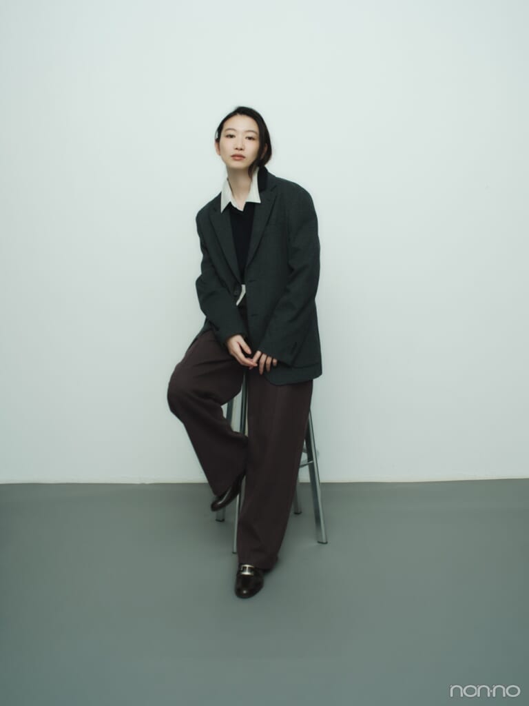 ユニクロのブラッシュドジャージーワイドパンツをオフィスカジュアル調に着こなし、椅子に座った岡本夏美の全身カット