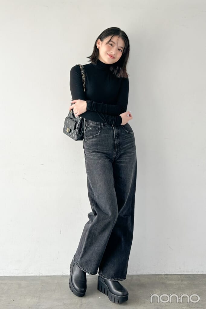 黒いタートルと黒のデニムパンツの出口夏希