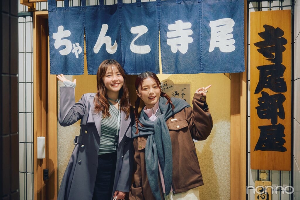 のれんの前に立つ久間田琳加と紺野彩夏