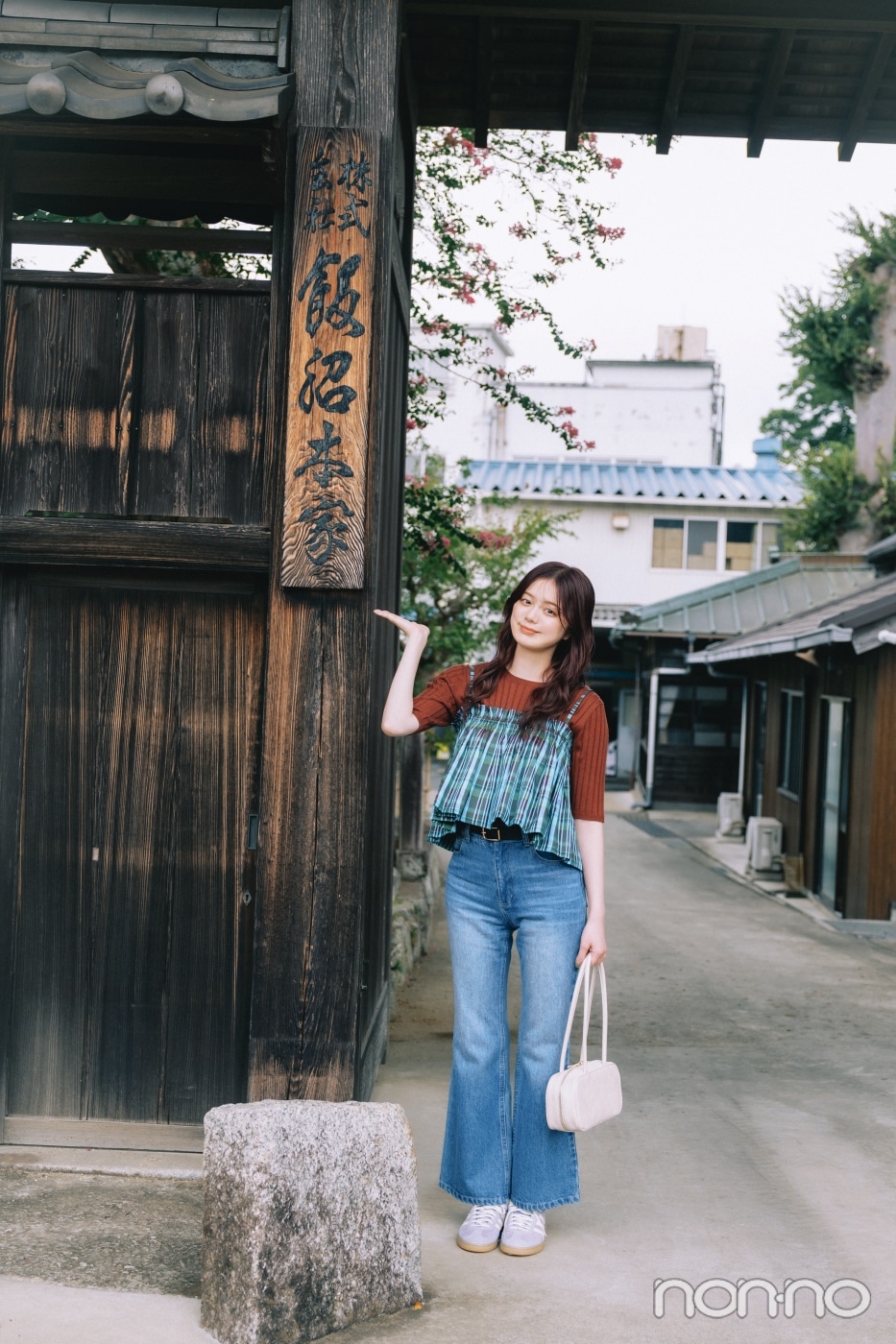 飯沼本家の看板の前に立つ紺野彩夏