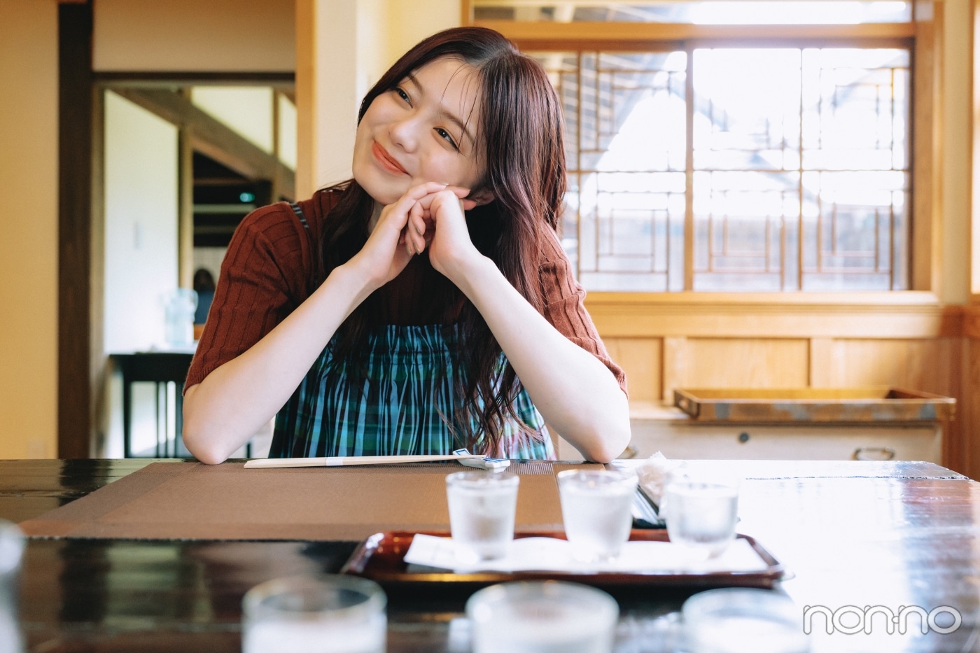 テーブルに肘をついて料理を待つ紺野彩夏