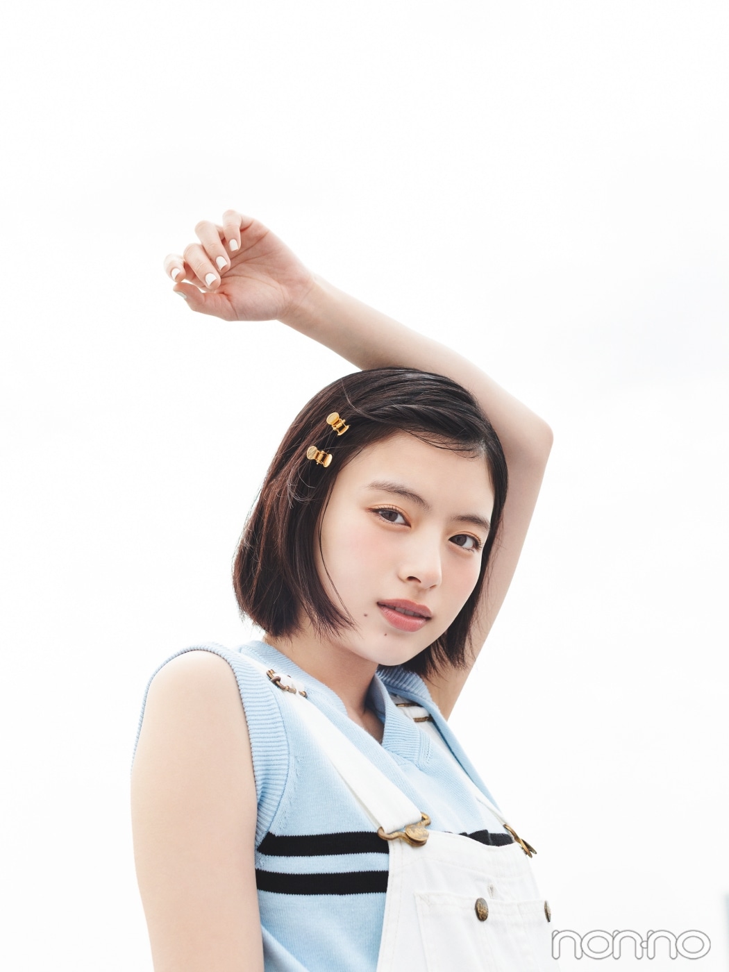 白いオーバーオールを着て、前髪にゴールドのクリップを二つ留めた出口夏希