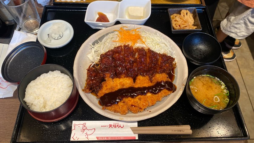 御膳わらじとんかつが中央に置いてあり右に味噌汁、左に白米、上に名古屋名物守口漬の写真。