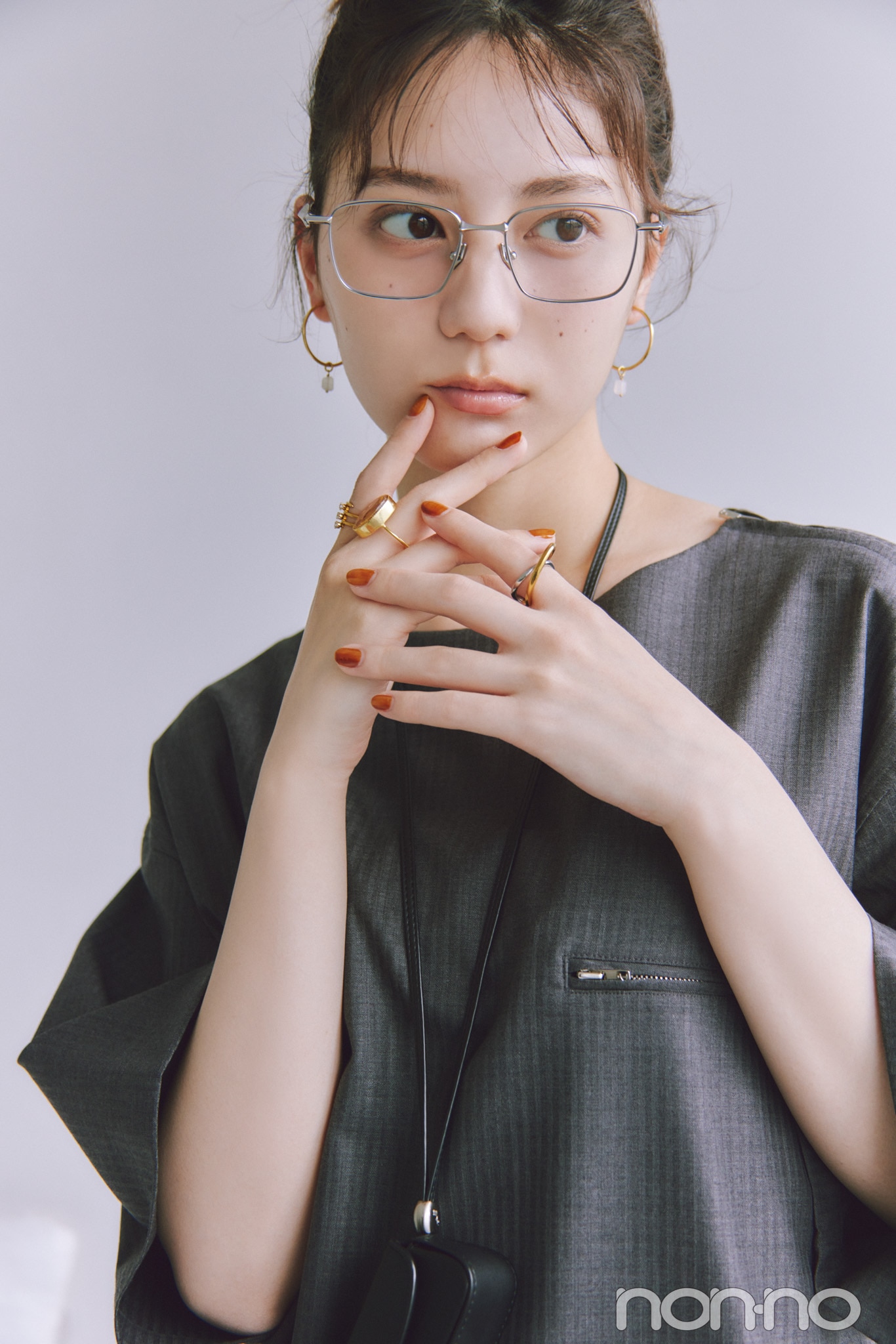 シルバーのスクエアメガネとゴールドのアクセをつけた小坂菜緒
