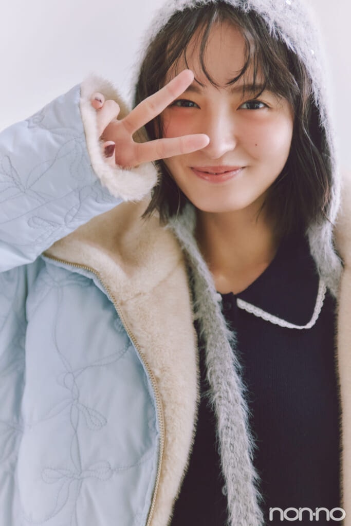 リボン柄キルティングコートを着てピースをする遠藤さくら