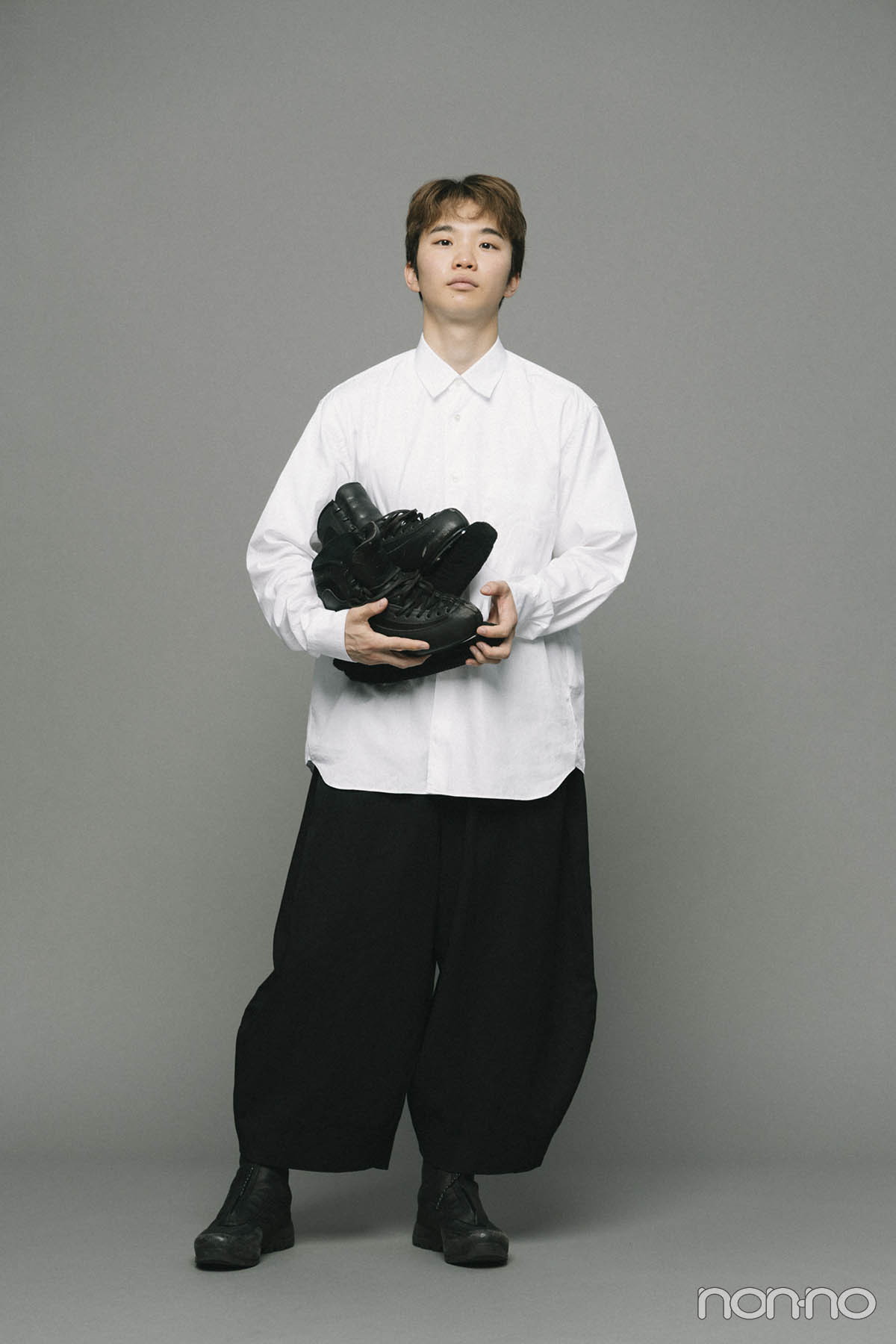 フィギュアスケート靴を手に立つ友野一希さんのノンノインタビューカット