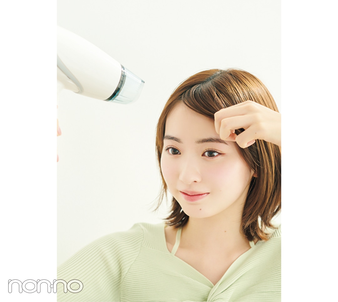 前髪をさわりながらドライヤーを充てる女性