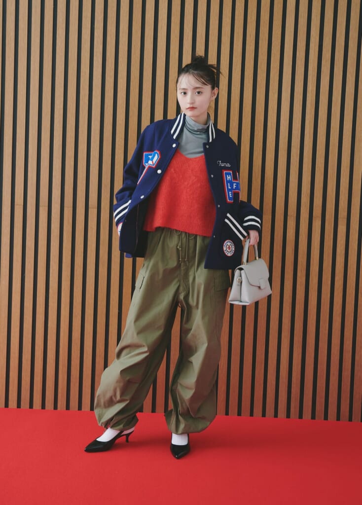 赤ニットキャミとブルゾンとカーゴパンツを合わせた赤ニットコーデの女性