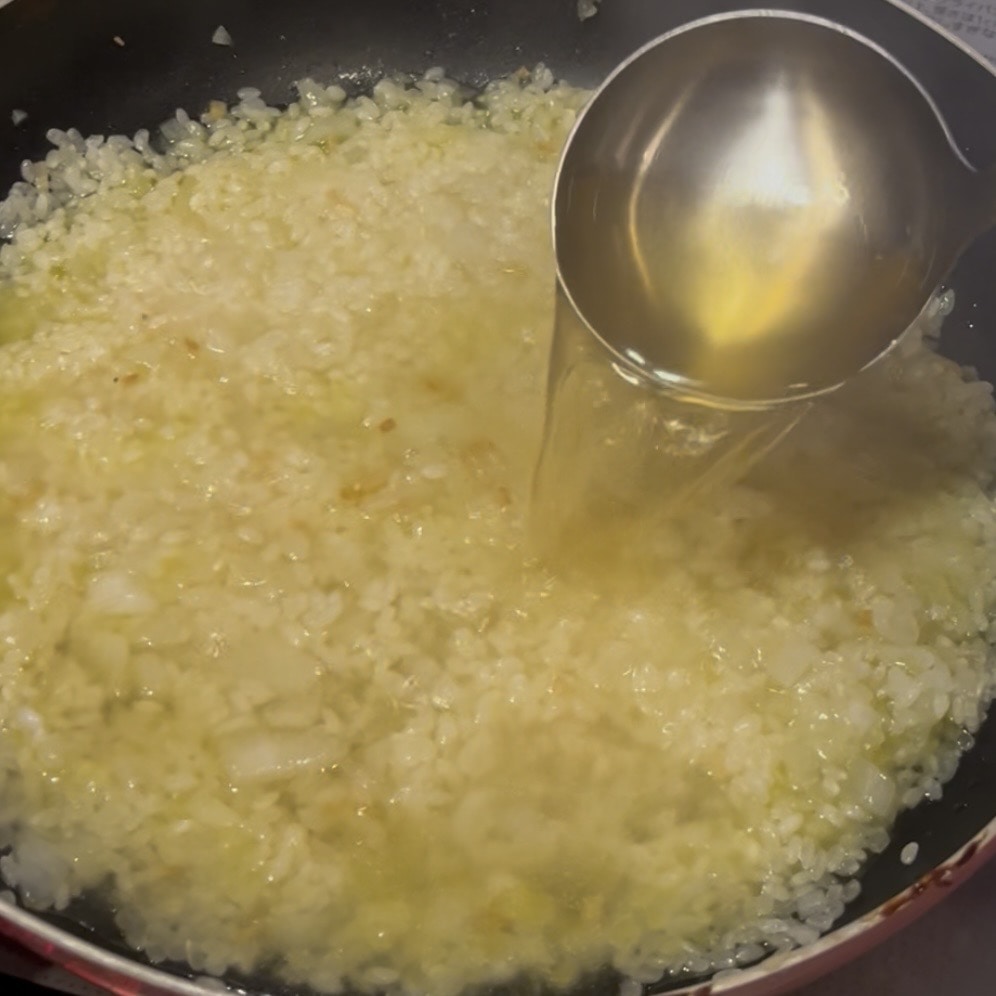 フライパンにコンソメスープを流し込んでいる