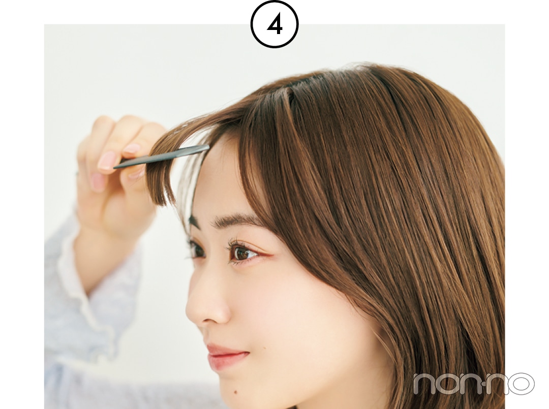 コームで内側から前髪のとかしている女性