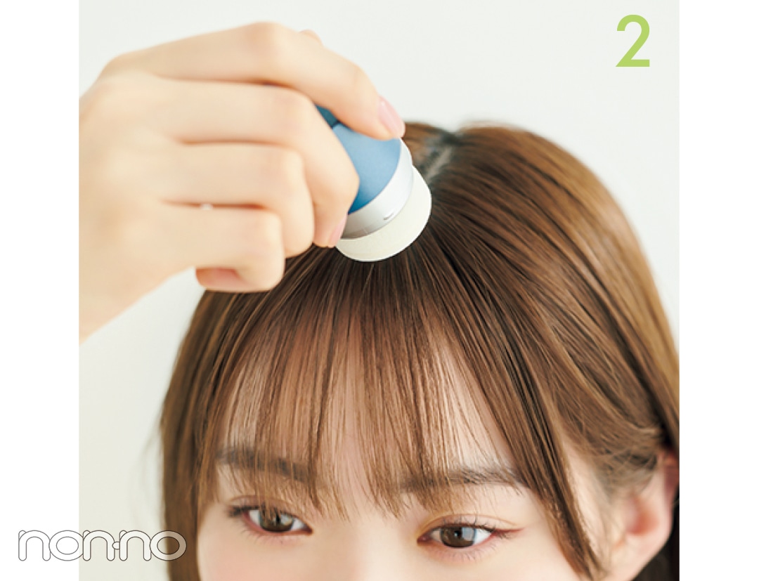 前髪の根本にパウダーを付ける女性