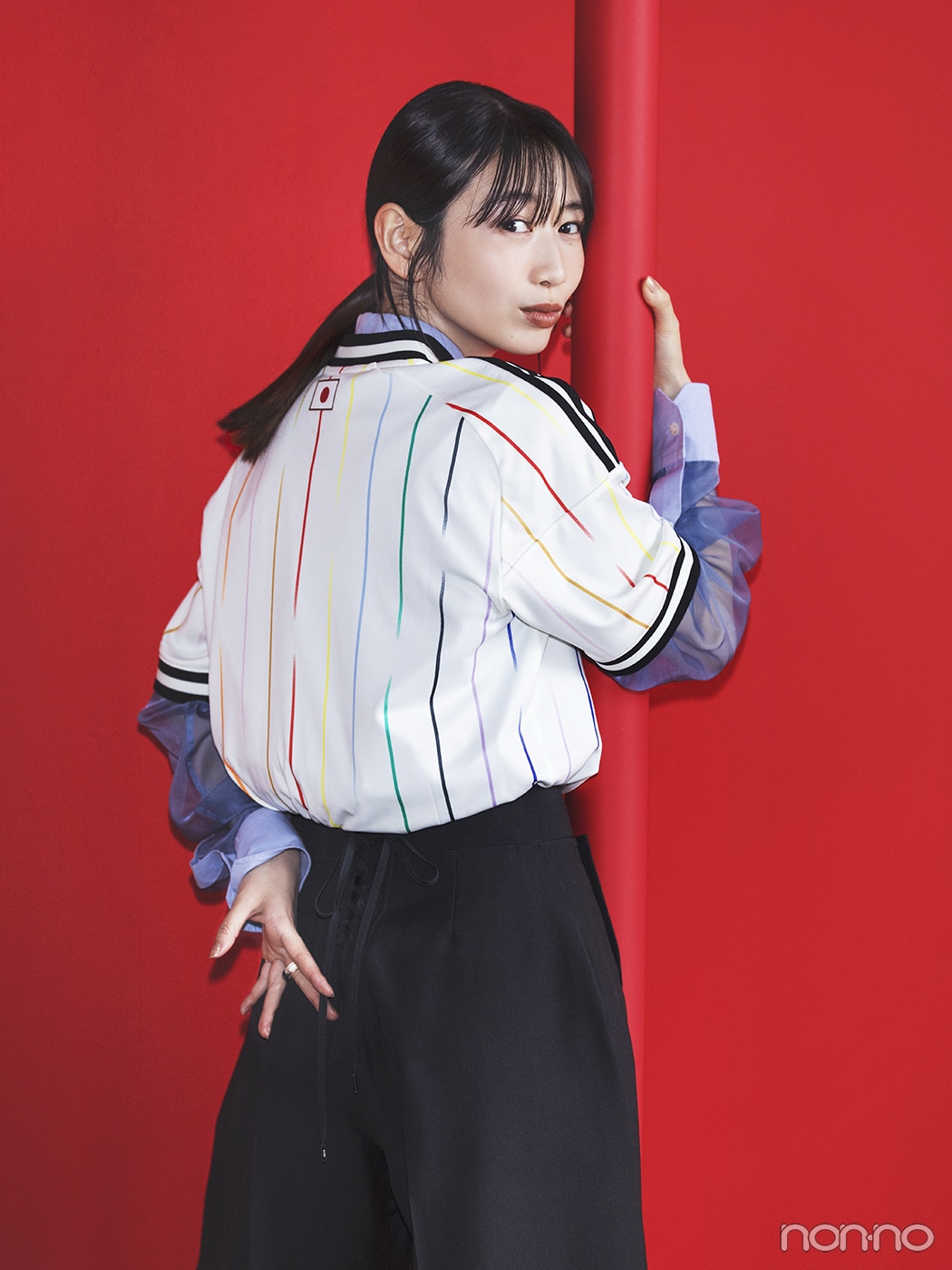 サッカー日本代表アウェイユニフォームとブルーシャツを重ねた岡本夏美の後ろ姿