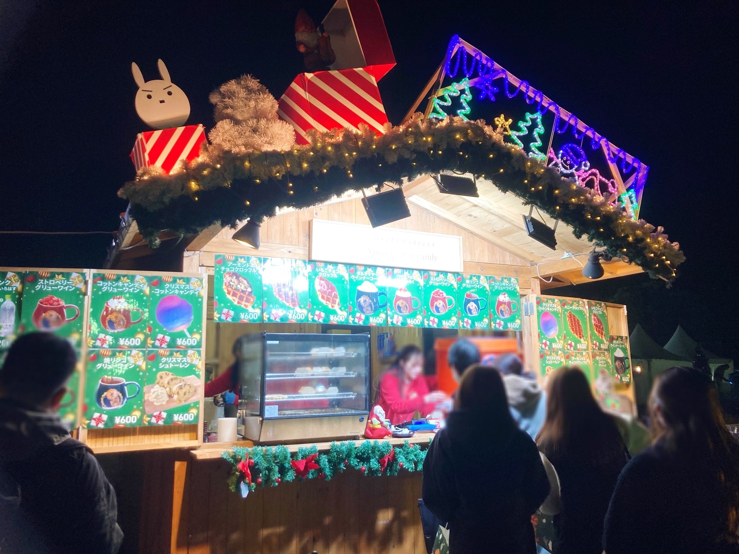 『東京クリスマスマーケット2023 in 明治神宮外苑』フード屋台。プレゼントボックスや電飾が屋根の上に乗っている。