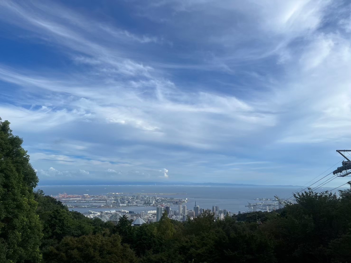 山頂から見える景色。海が広がっており、建物もたくさん見える。かなり高い場所から眺めることができる。