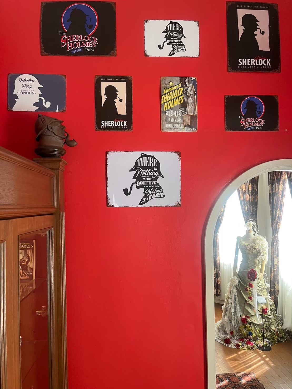 赤い壁にホームズの色々な横顔の影絵が飾られている。