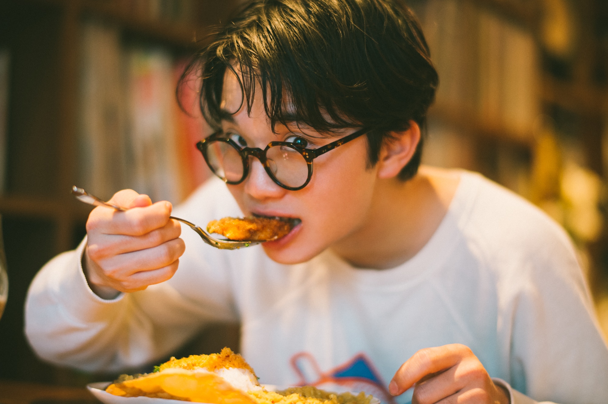 高円寺「ピピネラ」でカレーをほおばる友野一希さん