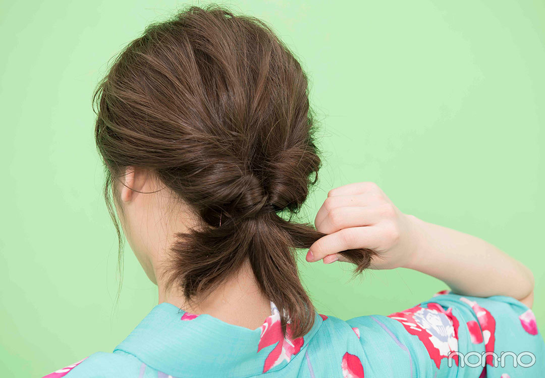 Step１. くるりんぱしたら毛束を３つに　髪全体を手ぐしでひとつにまとめてゴムで結ぶ。くるりんぱしたら毛束を３つに分ける。