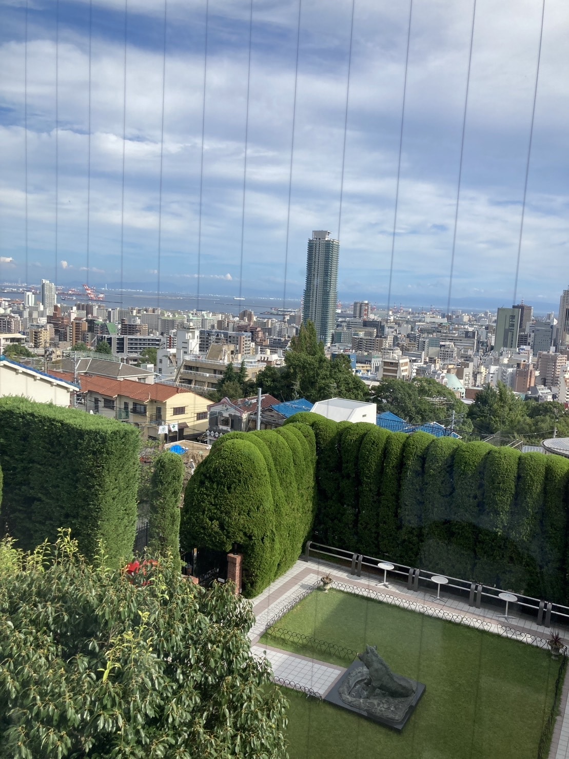 うろこの家からの景色。きれいな庭と神戸の海と建物が見渡せる。
