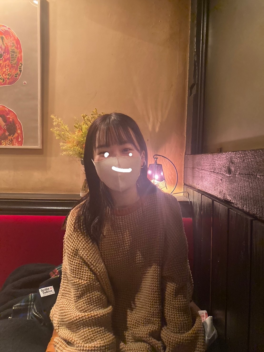 「TINA:JOJUN」のオレンジ色のワッフルニットを着た女の子