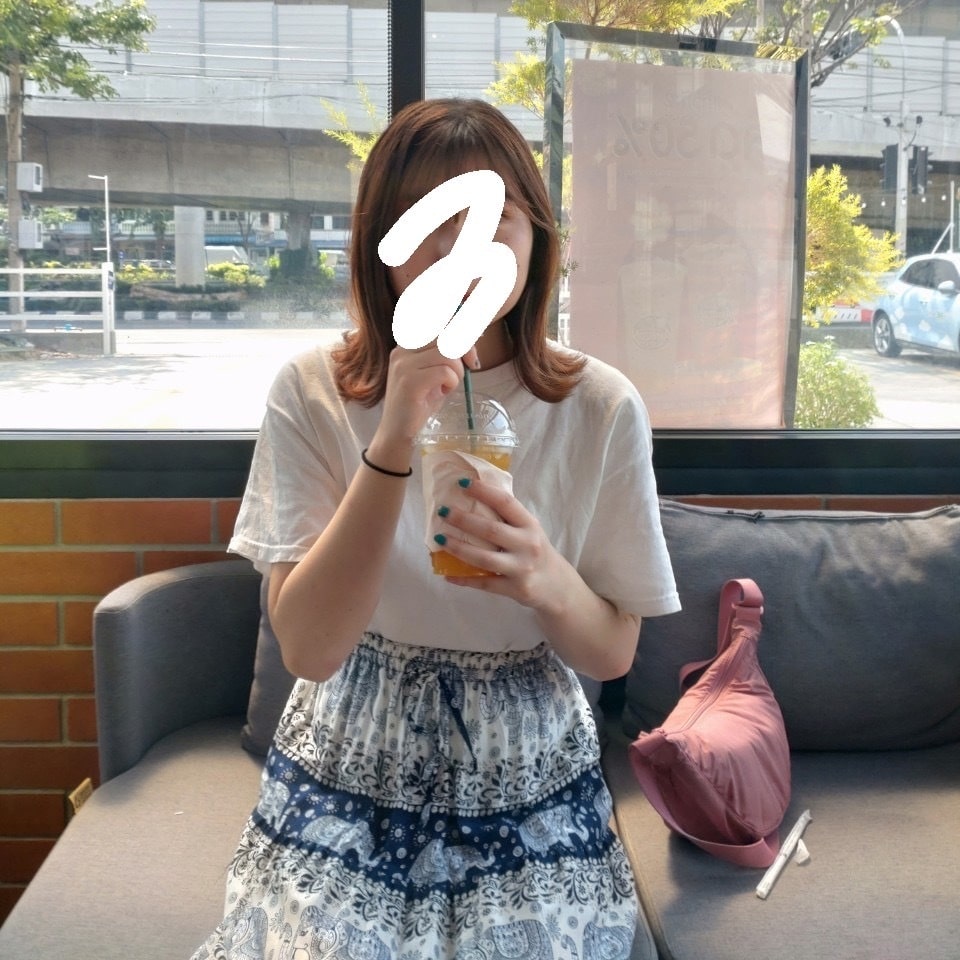 タイのスカートを履いている時の写真。白ティーに紺色のタイスカートをはいている。