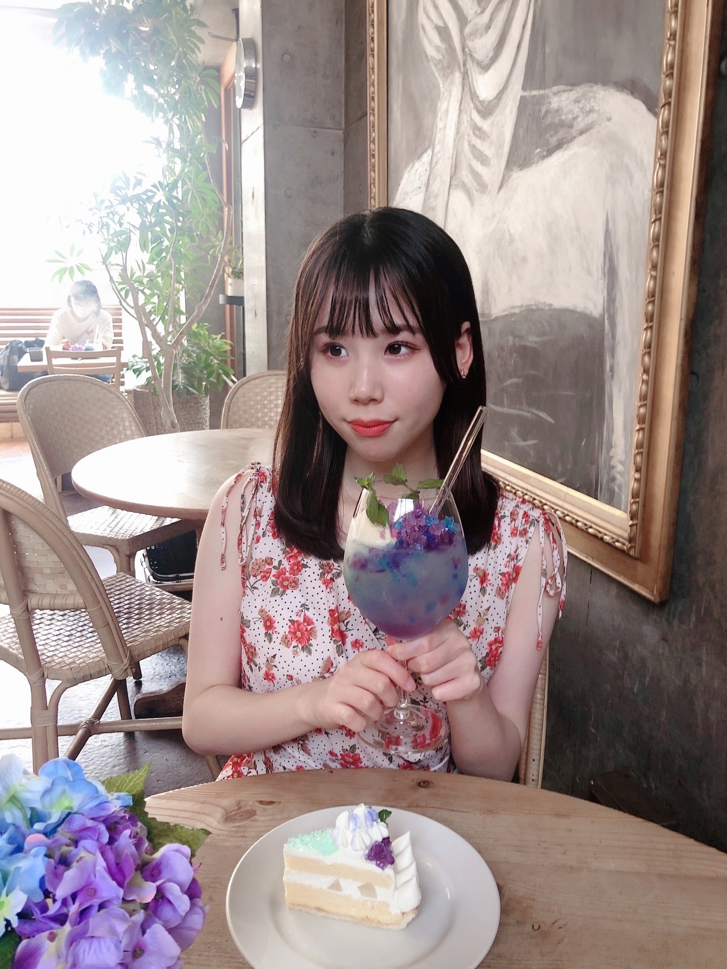 カフェでグラスを持つ黒崎愛萌